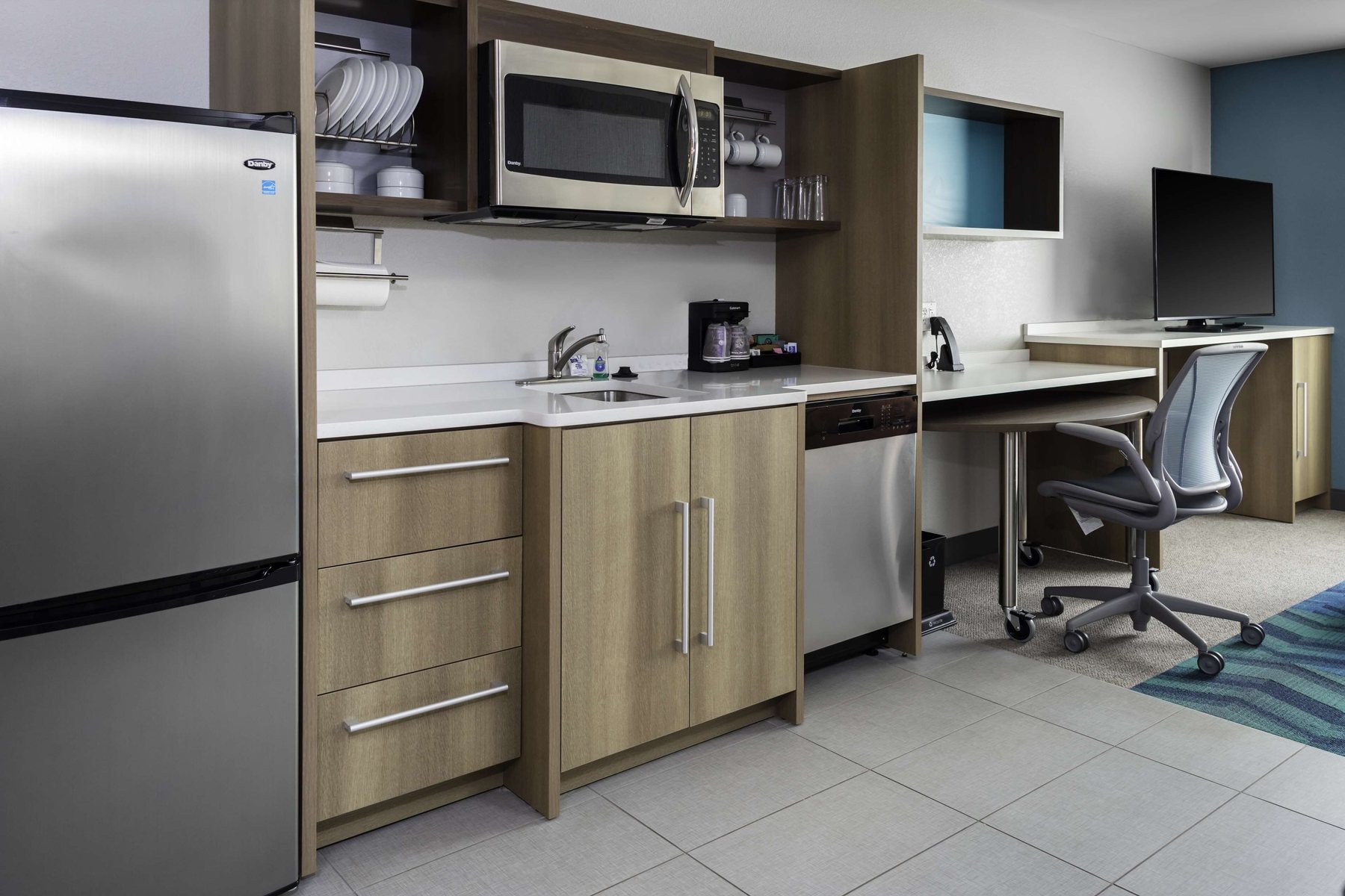 Home2 Suites in-suite kitchen with full-size refrigerator and work desk