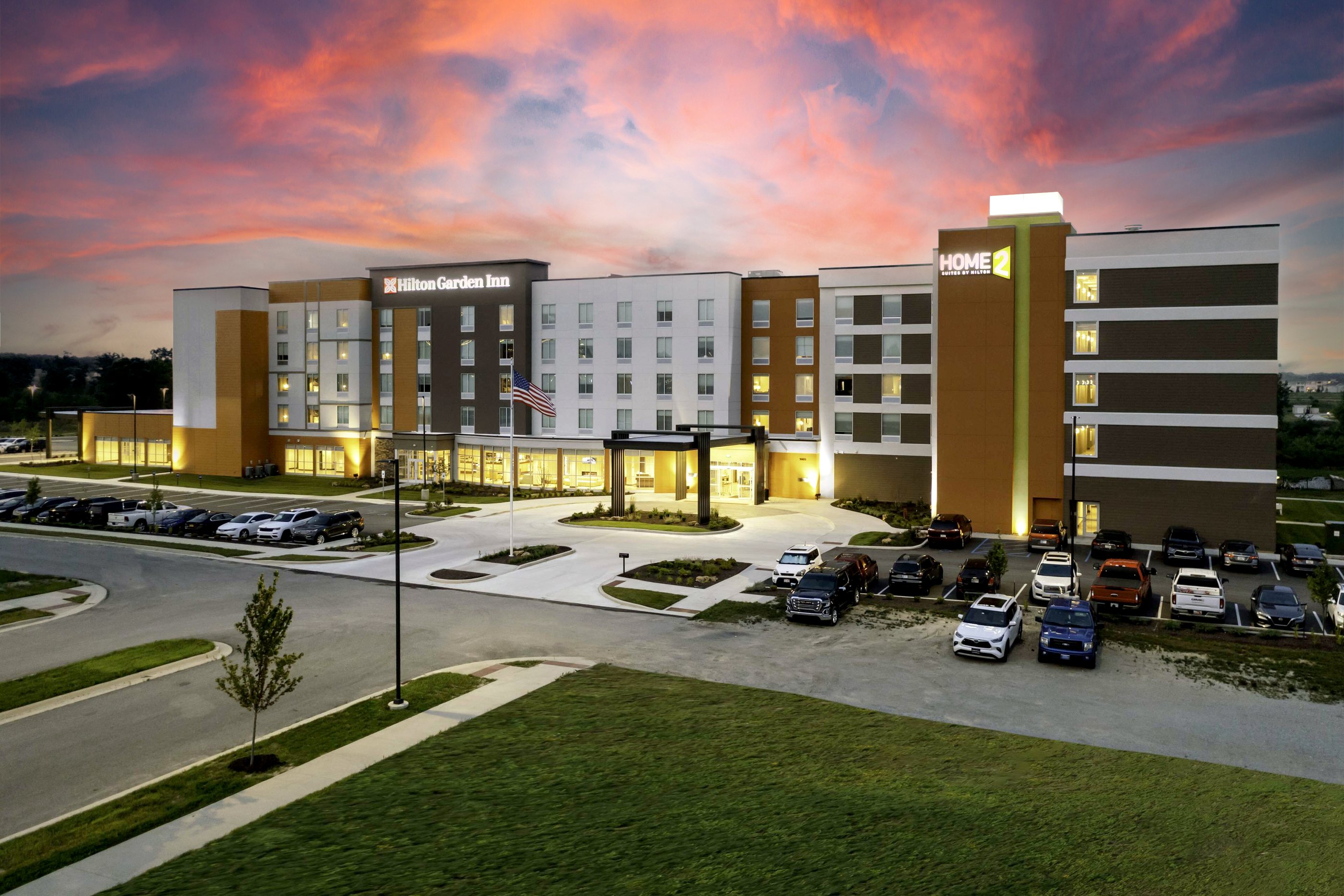 Home2 Suites and Hilton Garden Inn Fort Wayne North dual-branded hotel exterior at dusk